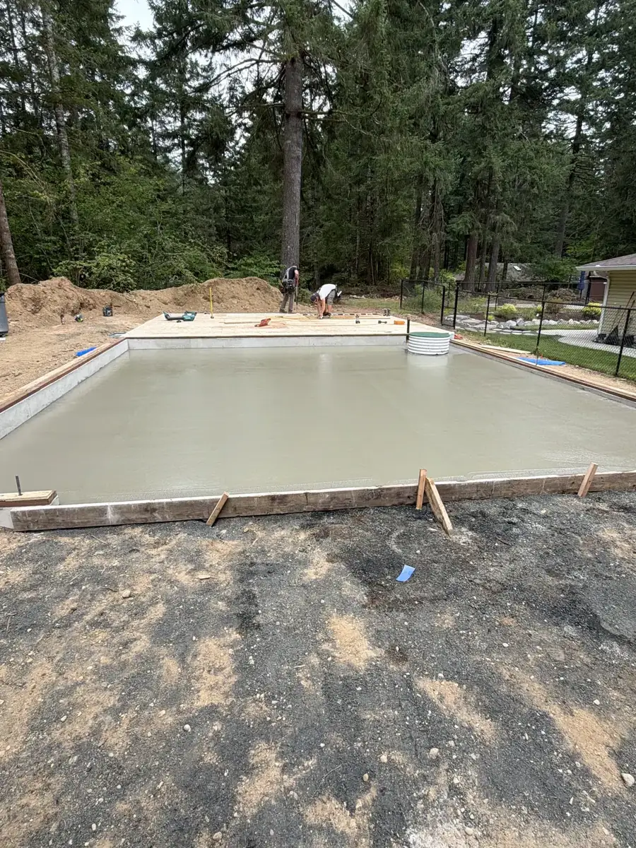 Large concrete slab poured and screeded among evergreen trees in Thurston County