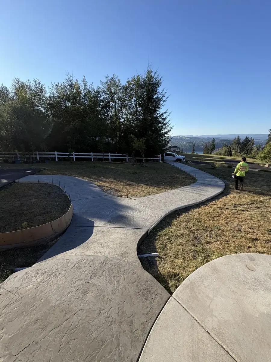 Curved stamped concrete walkway leading through a lawn at a home in the Olympia, WA area